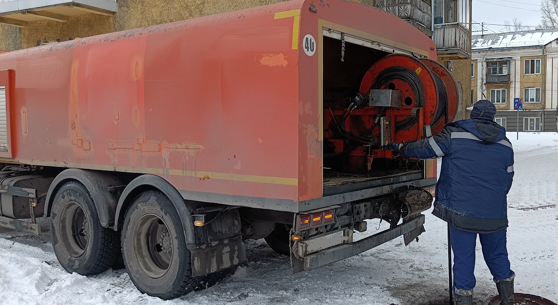 Каналопромывочная машина и работник прочищают засор в канализационной системе в Кромах